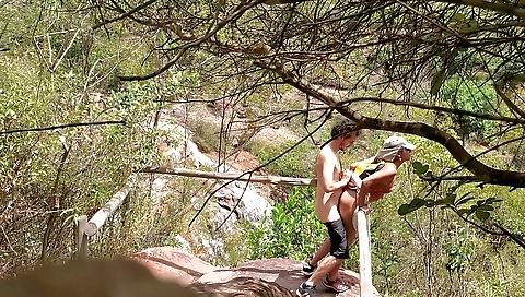 Man filmed on a waterfall and a couple of girls on top of it